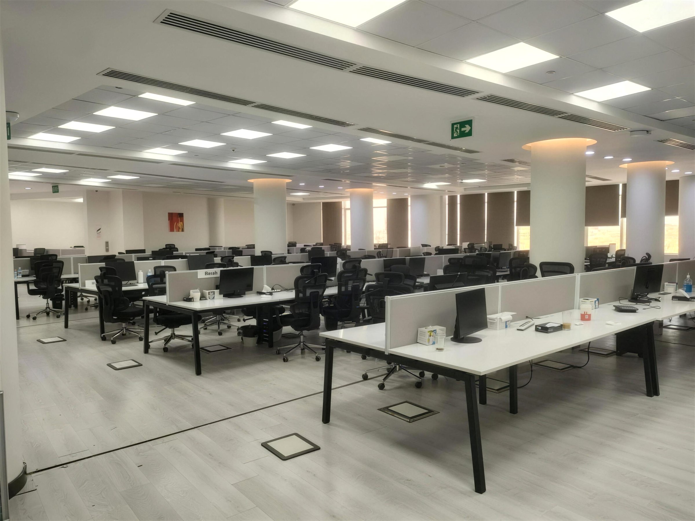 The Fitted Floor — open-plan office with rows of workstations under a bright ceiling grid